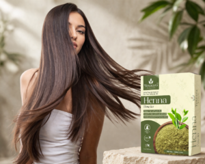 with long, smooth brown hair posing beside Yesaara Naturals Henna Powder box on a natural stone surface.